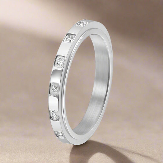 Silver ring with embedded stones on a light background